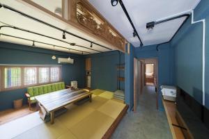 a living room with a green couch and blue walls at 江ノ島の島内で一棟貸し一日一組限定はまさき旅館 in Fujisawa