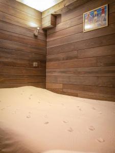 a bedroom with wood paneling and a bed in it at Ski Chalet located Meribell in Les Allues