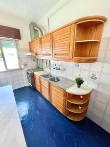 a kitchen with wooden cabinets and a blue floor at New in Loures in Lisbon