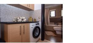 ein Badezimmer mit Waschmaschine und Toilette in der Unterkunft Jack Villa's in Chavgas