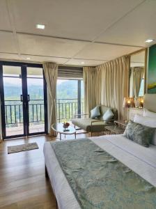 a bedroom with a large bed and a living room at Hummingbird St.Clare Villas in Dimbula