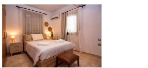 ein Schlafzimmer mit einem Bett, einem Stuhl und einem Fenster in der Unterkunft Jack Villa's in Chavgas