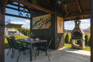 a patio with a table and chairs and a pizza oven at LakeHome&Spa nad Jeziorem Czorsztyńskim in Kluszkowce
