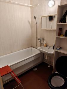 a small bathroom with a tub and a sink at Sunny 4th-Floor Park-View Studio Escape in Turku