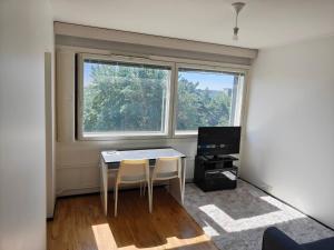 a room with a table and two chairs and a window at Sunny 4th-Floor Park-View Studio Escape in Turku