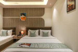 a bedroom with two beds and a table with a lamp at Perfectstayz Premium Vrindavan - Near Prem Mandir in Vrindāvan