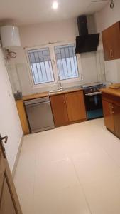 a kitchen with two windows and a kitchen with white floors at Duplex nr 3 à Bandal in Kinshasa