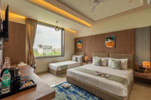 a hotel room with two beds and a window at Perfectstayz Premium Vrindavan - Near Prem Mandir in Vrindāvan
