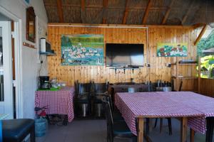 a dining room with two tables and a flat screen tv at Casa 9 in Sfântu Gheorghe
