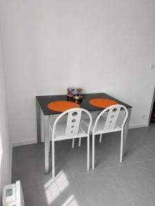 a black table with two white chairs around it at violette 3 in La Souterraine