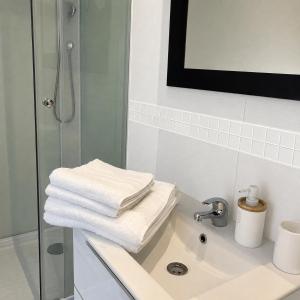 a bathroom with a shower and towels on a sink at violette 3 in La Souterraine