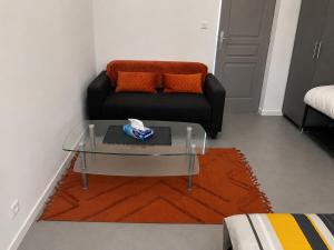 a living room with a glass coffee table and a couch at violette 3 in La Souterraine