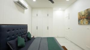 a bedroom with a large bed with green pillows at The Afternoon Stays in Mohali