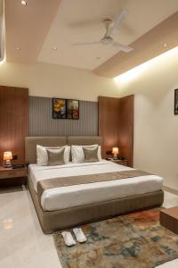 a bedroom with a large bed with two lamps and a rug at Perfectstayz Premium Vrindavan - Near Prem Mandir in Vrindāvan