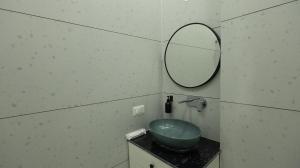a bathroom with a green sink and a mirror at The Afternoon Stays in Mohali +17 photos