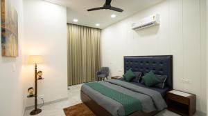 a bedroom with a bed and a chair in a room at The Afternoon Stays in Mohali