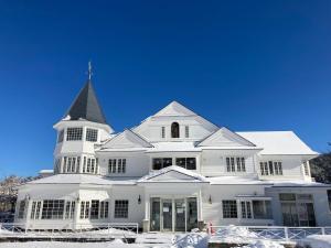 a white house with a steeple in the snow at WhiteRunse in Takayama