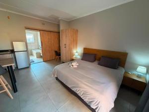 a bedroom with a large bed and a bathroom at Green Haven 2 in Tzaneen