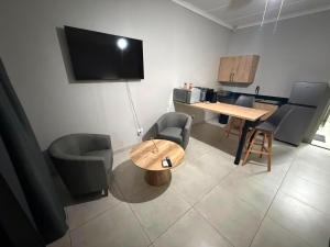 a living room with a table and chairs and a television at Green Haven 2 in Tzaneen