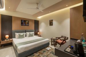 a hotel room with a bed and a desk and a table sidx sidx at Perfectstayz Premium Vrindavan - Near Prem Mandir in Vrindāvan