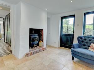 a living room with a blue chair and a fireplace at Swallows Bottom in Henley +28 photos