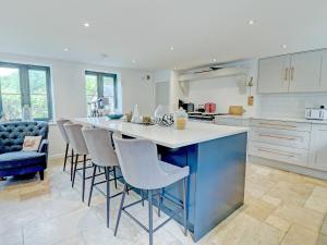 a kitchen with a large island with bar stools at Swallows Bottom in Henley
