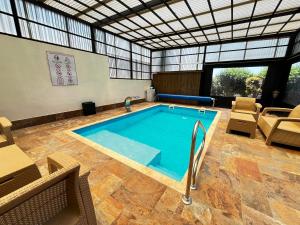 a large swimming pool in a building with chairs at Zimmer Monte in Dāliyat el Karmil