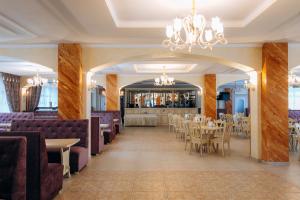 a restaurant with tables and chairs and a bar at Kasimir Hotel & SPA in Bukovel