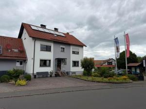 a white house with two flags in front of it at Ferienwohnung Ehrenberg-Feeling in Ehrenberg