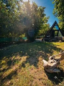 a log sitting on the grass in a field at A frame ti i ja in Smederevska Palanka