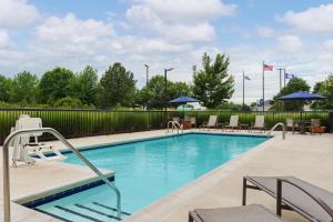 a pool with chairs and umbrellas at a hotel at Hampton Inn Farmville in Farmville