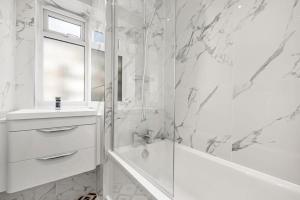 a bathroom with a shower and a tub and a sink at Spacious London Bridge Flat in London