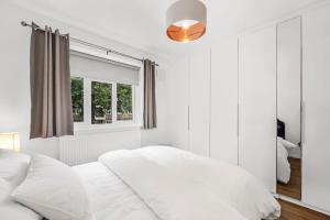 a white bedroom with a bed and a window at Spacious London Bridge Flat in London