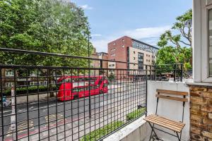 a red double decker bus on a city street at Spacious London Bridge Flat in London