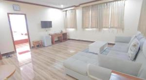 a living room with a white couch and a television at The Mou Hotel in Phnom Penh