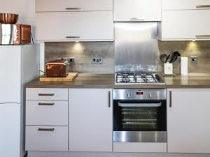 a kitchen with white cabinets and a stove at Serenity in Cellardyke