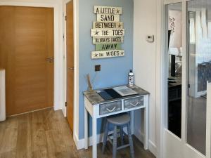 a room with a desk and a sign on the wall at Serenity in Cellardyke +10 photos