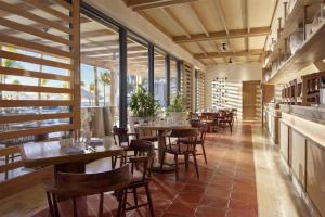 a restaurant with wooden tables and chairs and windows at Alila Mayakoba by Hyatt in Playa del Carmen