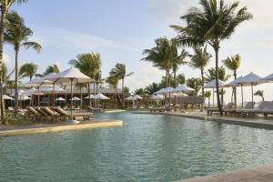 a pool at a resort with chairs and umbrellas at Alila Mayakoba by Hyatt in Playa del Carmen
