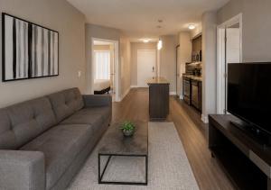 a living room with a couch and a television at Oak Crown Suites in Toronto