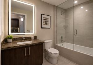 a bathroom with a toilet and a sink and a shower at Oak Crown Suites in Toronto