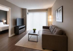 a living room with a couch and a tv and a bed at Oak Crown Suites in Toronto