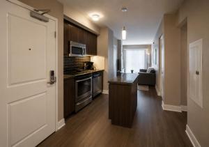 a kitchen with a door open to a living room at Oak Crown Suites in Toronto