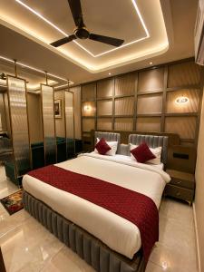 a bedroom with a large bed with red pillows at Panipat Prime in Pānīpat