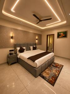 a bedroom with a large bed with a ceiling at Panipat Prime in Pānīpat +22 photos