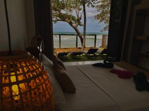 a bedroom with a bed with a view of the beach at Bloom Beach Villa in Batigama +38 photos