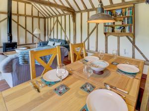 a dining room table with plates and glasses on it at Glebe Stables in Steyning