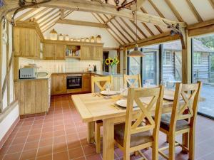 a kitchen with a wooden table and chairs at Glebe Stables in Steyning