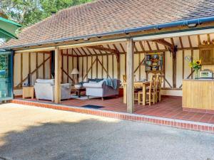 a large wooden pavilion with a table and chairs at Glebe Stables in Steyning