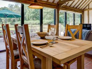 a wooden table with chairs and a dining room at Glebe Stables in Steyning +13 photos